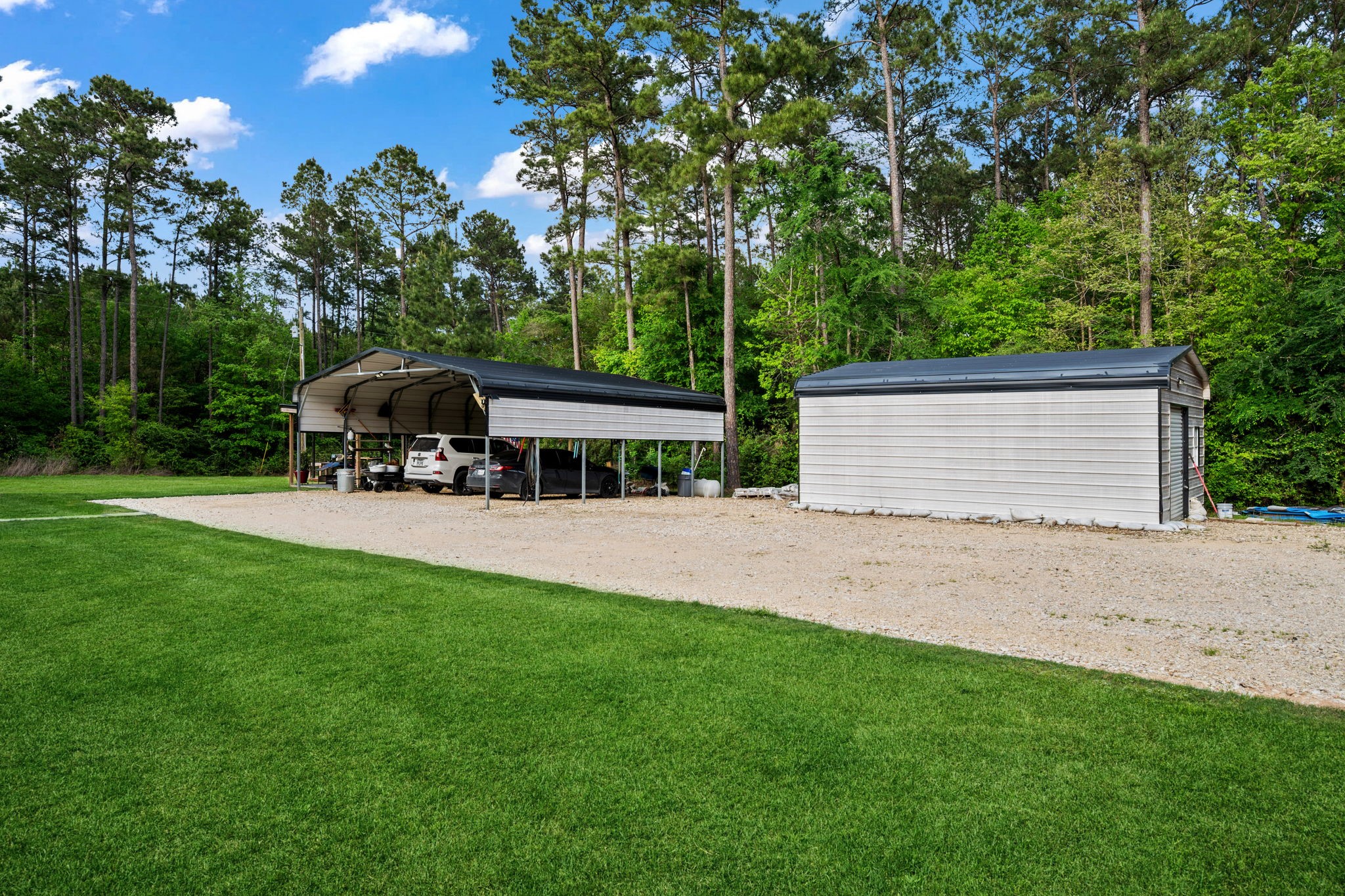 625-635 Gibson Road Livingston, TX 77351 - Photo 3 of 49 Home #1 has a fully enclosed metal garage, covered carport and covered patio area with a grass area for practice.