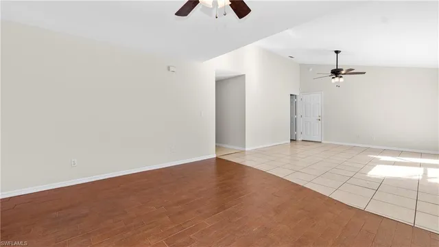 an empty room with a ceiling fan and window