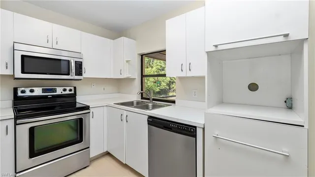 a kitchen with cabinets appliances and a window