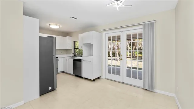 a kitchen with stainless steel appliances a refrigerator and a chandelier