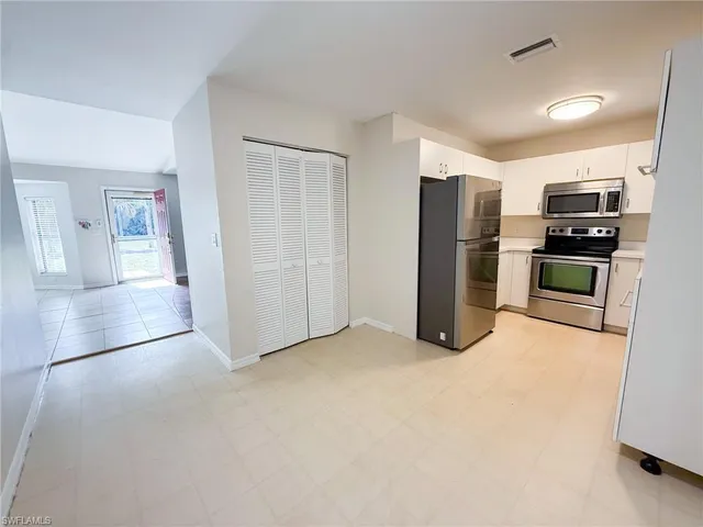 a view of kitchen with refrigerator stove and window