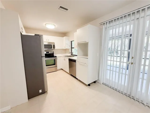 a kitchen with stainless steel appliances a refrigerator and a stove top oven