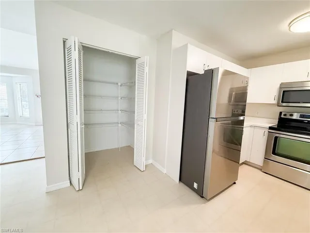 a kitchen with stainless steel appliances a refrigerator and cabinets