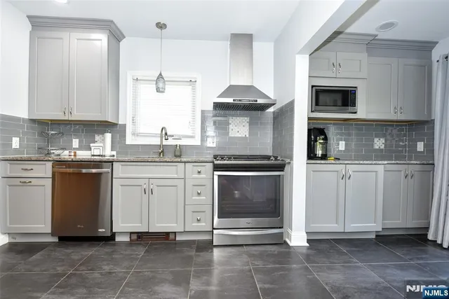 a kitchen with stainless steel appliances granite countertop a stove refrigerator sink and cabinets