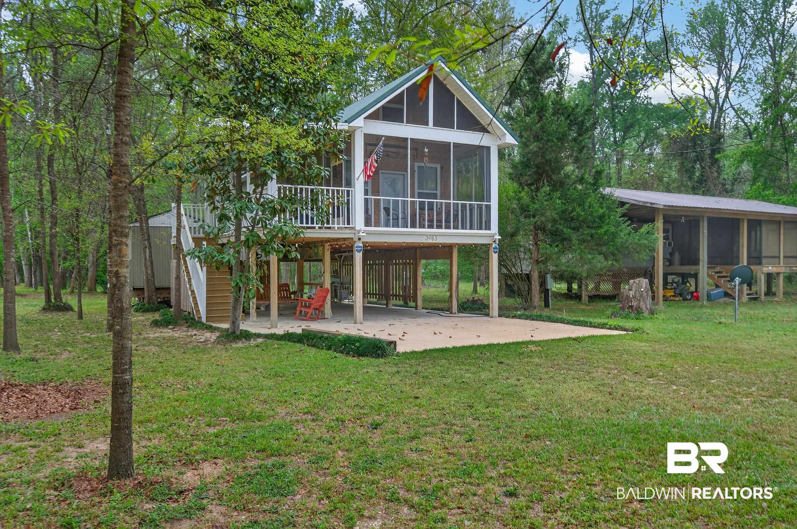 3983 Eureka Landing Road Uriah, AL 36480 - Photo 1 of 45 Rear view of property with a sunroom, a patio, a lawn, and a carport