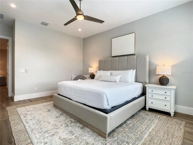 a bedroom with a bed and a lamp on dresser