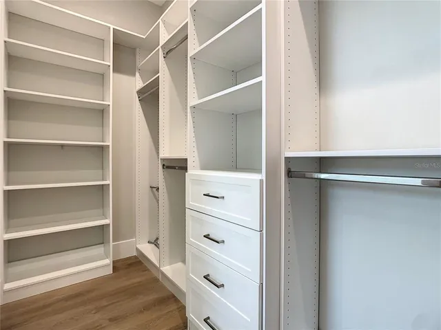 a view of walk in closet with empty racks