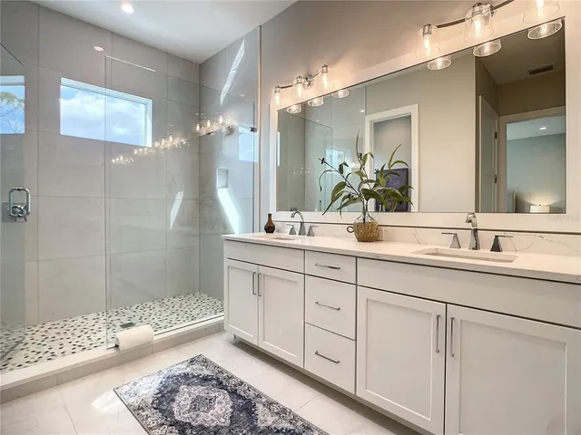 a bathroom with a double vanity sink mirror and shower
