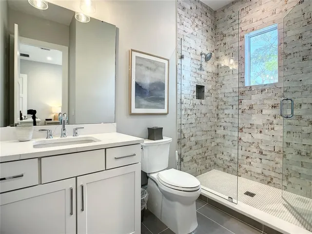 a bathroom with a sink a toilet and shower