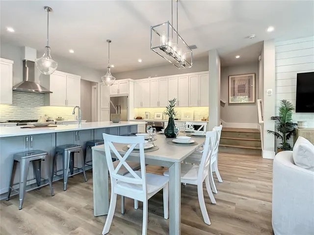a view of a dining room and livingroom with furniture wooden floor a chandelier