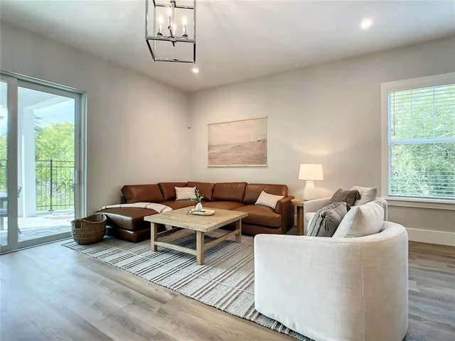 a living room with couches a coffee table and four couches with wooden floor