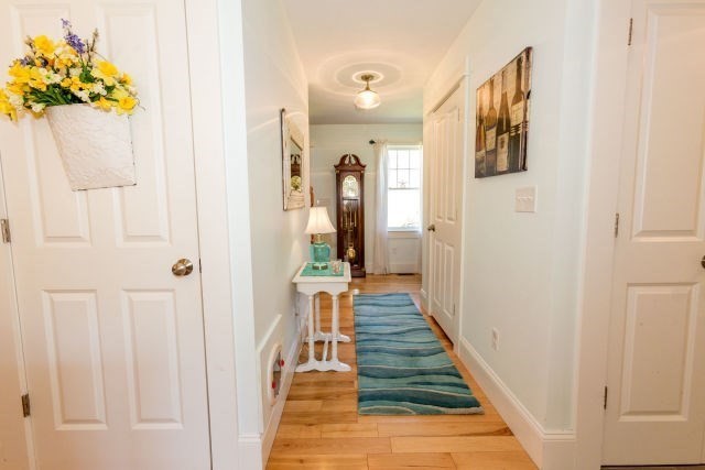 140 Warren Street Upton, MA 01568 - Photo 11 of 37 a view of a hallway with wooden floor and a bathroom