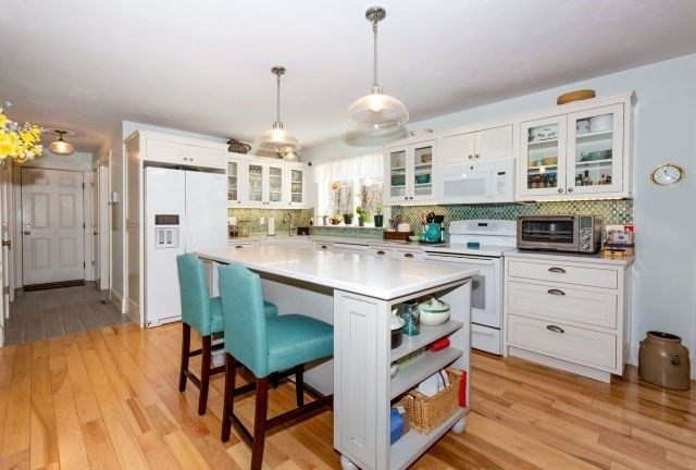 140 Warren Street Upton, MA 01568 - Photo 4 of 37 a kitchen with kitchen island a stove a table and chairs in it