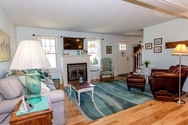 140 Warren Street Upton, MA 01568 - Photo 9 of 37 a living room with furniture a flat screen tv and a fireplace