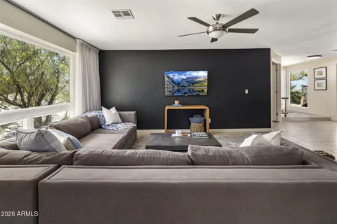 a living room with furniture a flat screen tv and a rug
