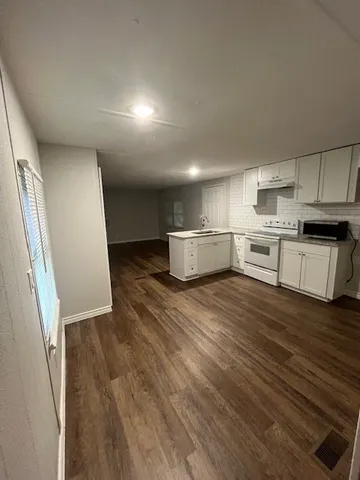 a kitchen with a sink and wooden floor