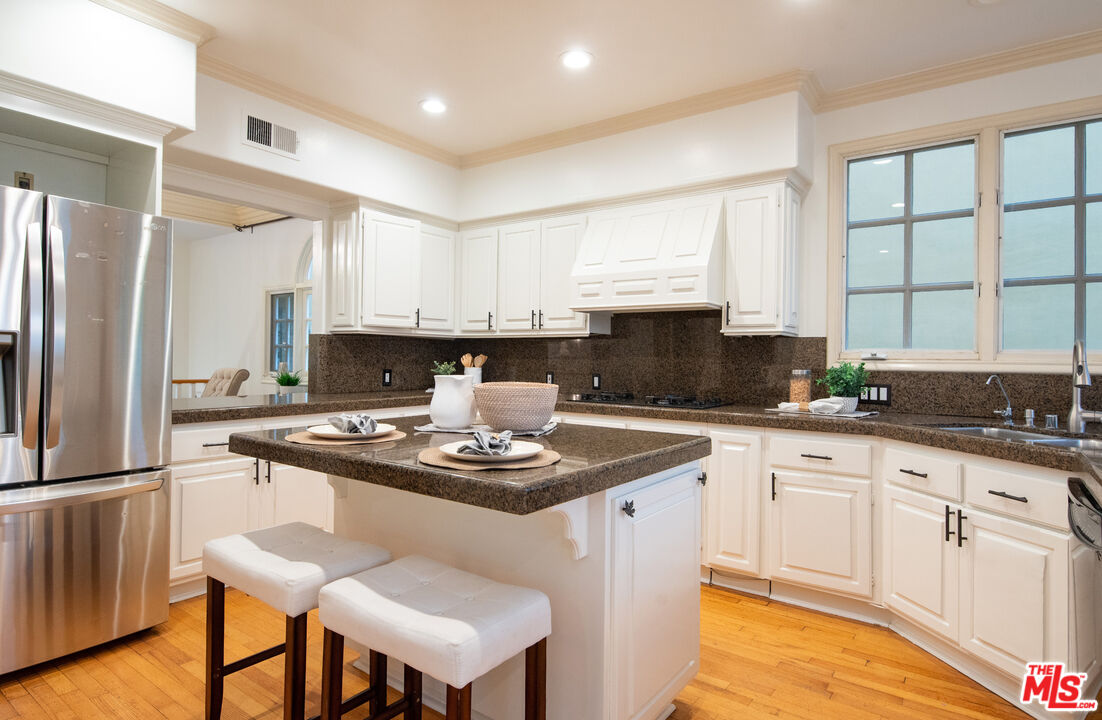 115 Roma Court Marina del Rey, CA 90292 - Photo 19 of 50 a kitchen with stainless steel appliances granite countertop a stove a sink dishwasher a refrigerator and white cabinets with wooden floor