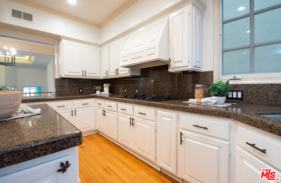 115 Roma Court Marina del Rey, CA 90292 - Photo 21 of 50 a kitchen with granite countertop a sink stainless steel appliances white cabinets and a window