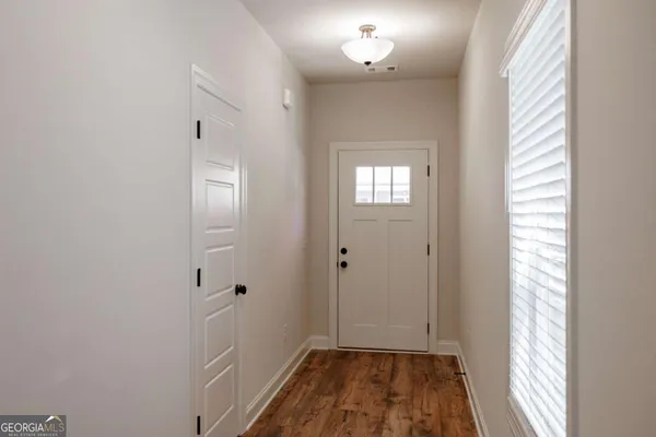 a kitchen with stainless steel appliances white cabinets and a stove a oven with wooden floor