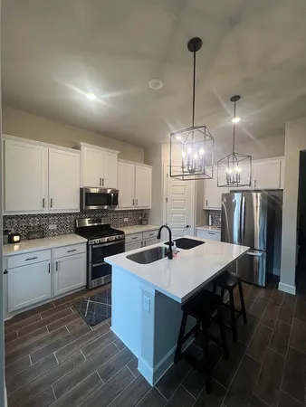 a kitchen with stainless steel appliances a refrigerator and a stove top oven