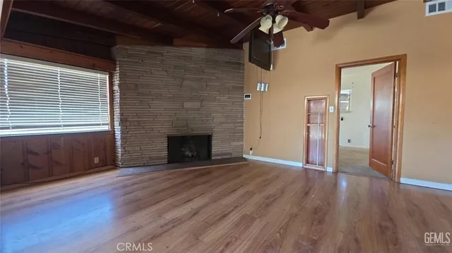 a view of a livingroom with wooden floor and a fireplace