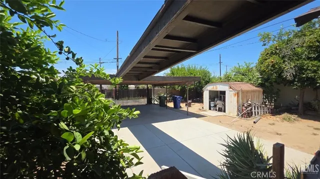 a view of a patio with table and chairs potted plants and large tree