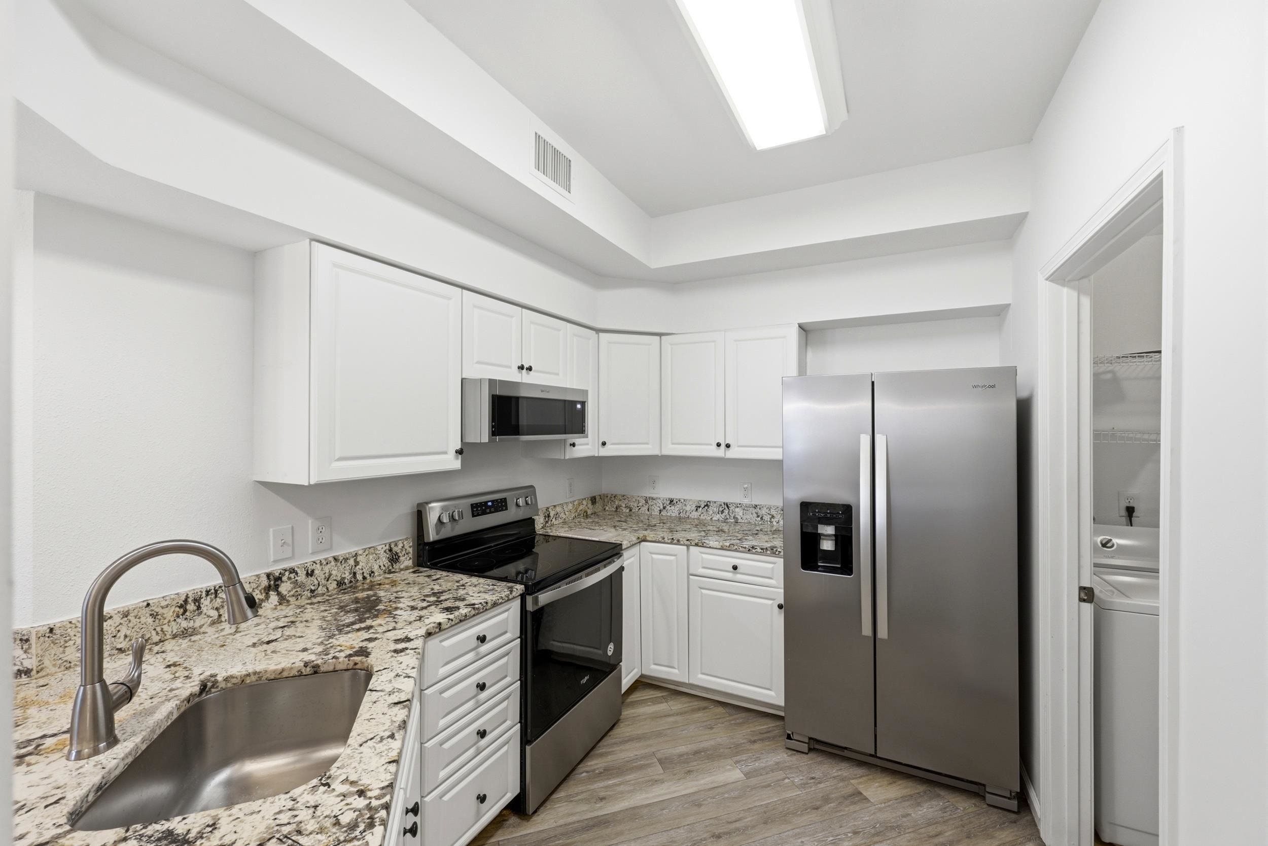 2500 Vista Cove Road St. Augustine, FL 32084 - Photo 9 of 53 a kitchen with stainless steel appliances granite countertop a refrigerator sink and white cabinets