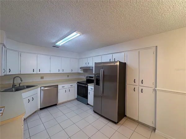 a kitchen with a refrigerator sink and cabinets