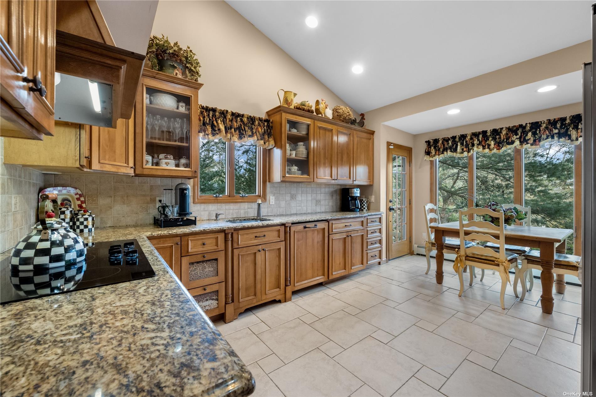 a kitchen with stainless steel appliances granite countertop a stove a sink and a dining table view