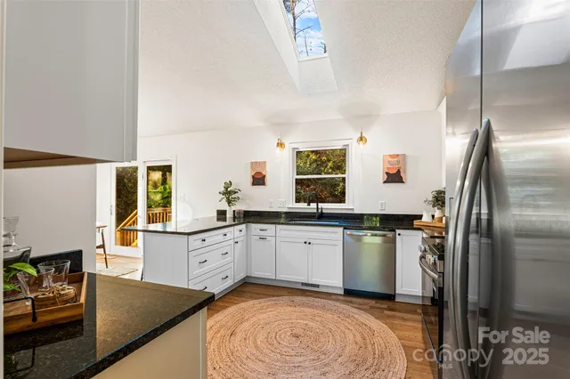 a kitchen with granite countertop a sink stainless steel appliances and cabinets