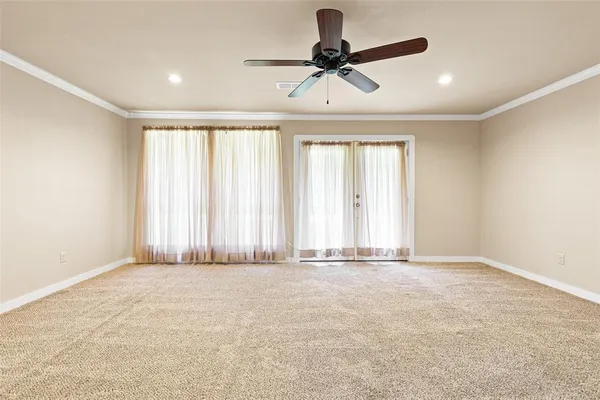 an empty room with a ceiling fan and window