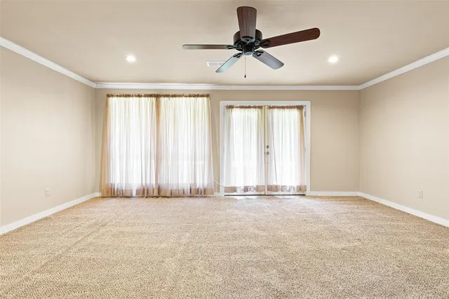 an empty room with a ceiling fan and window