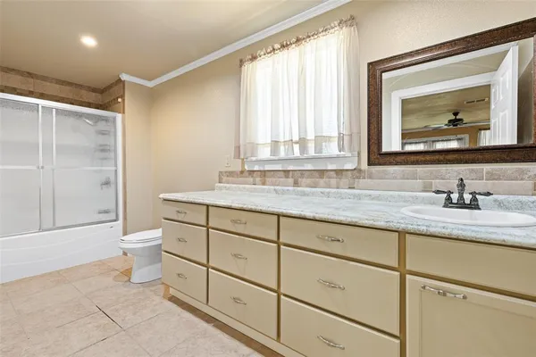 a bathroom with double vanity sink a mirror and a toilet