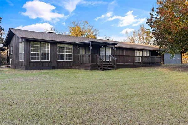 a view of a house with wooden fence and a floor to ceiling window