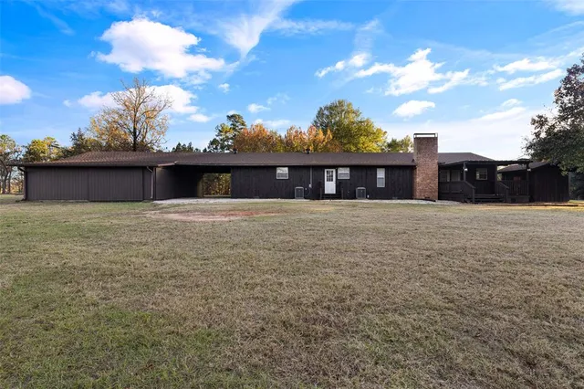 a view of wooden house with a large window and wooden fence