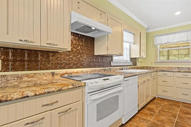 a kitchen with granite countertop white cabinets and white appliances