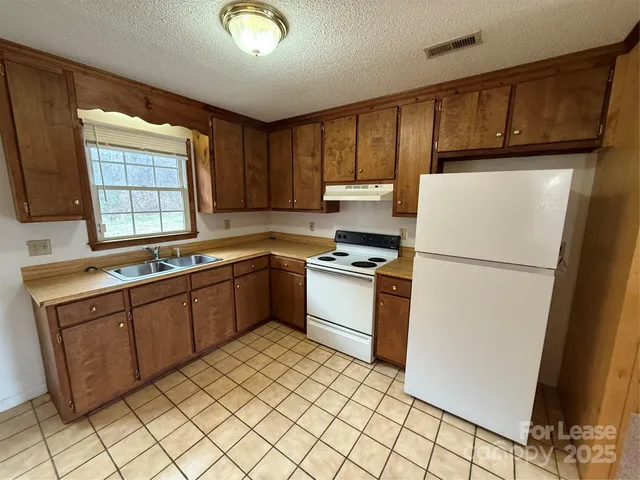 a kitchen with a refrigerator sink and cabinets