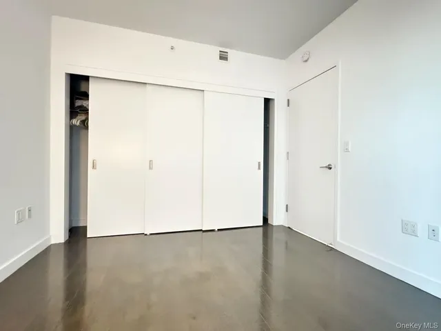 an empty room with wooden floor and a window