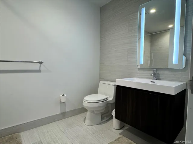 a bathroom with a sink toilet and a mirror