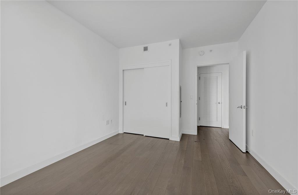 131-03 40 Road, Unit 16D Queens, NY 11354 - Photo 9 of 16 a view of a room with wooden floor