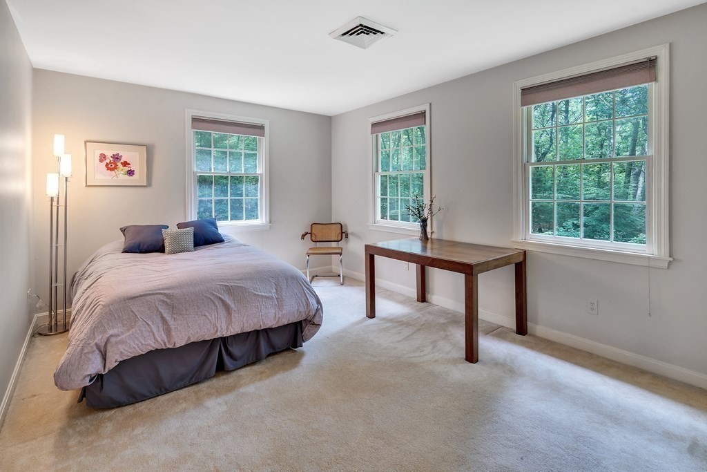 1031 Boston Post Road Sudbury, MA 01776 - Photo 22 of 36 a bedroom with a bed a table and windows