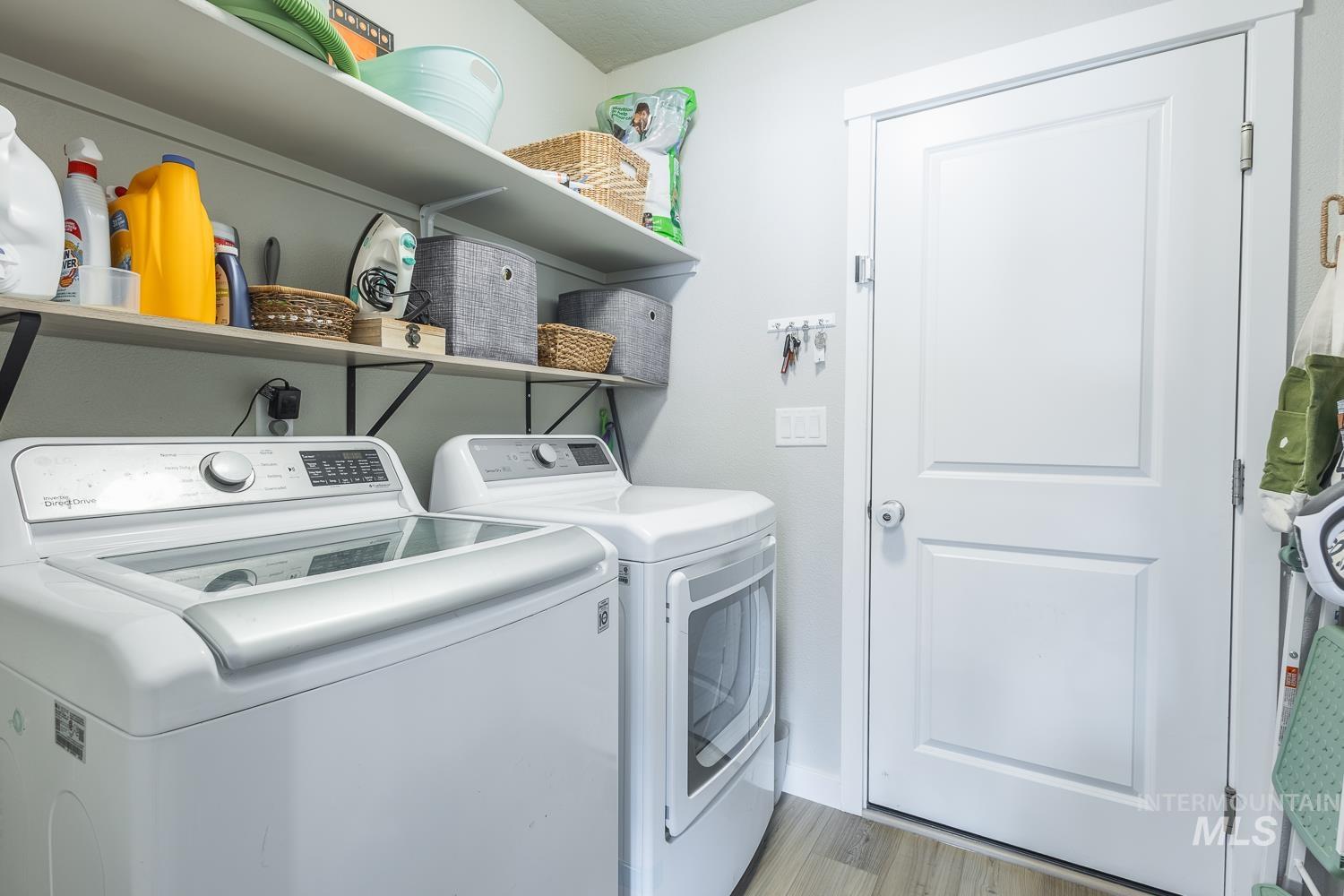 12623 Shadow Peak Street Caldwell, ID 83607 - Photo 46 of 50 Dedicated laundry area featuring a top-load washing machine, front-load dryer, and two wall-mounted storage shelves