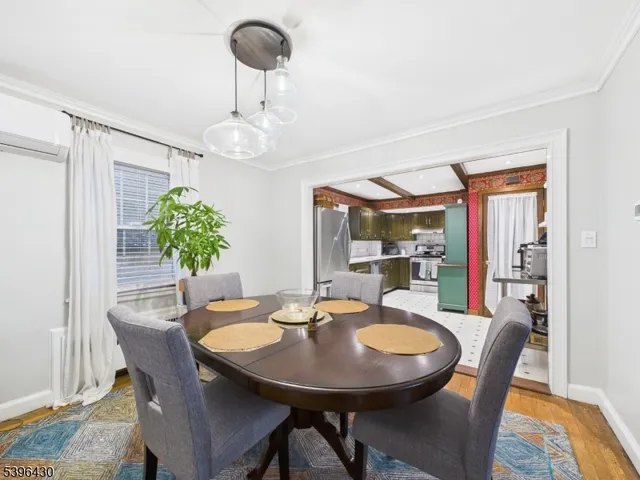 a dining room with furniture a potted plant and wooden floor