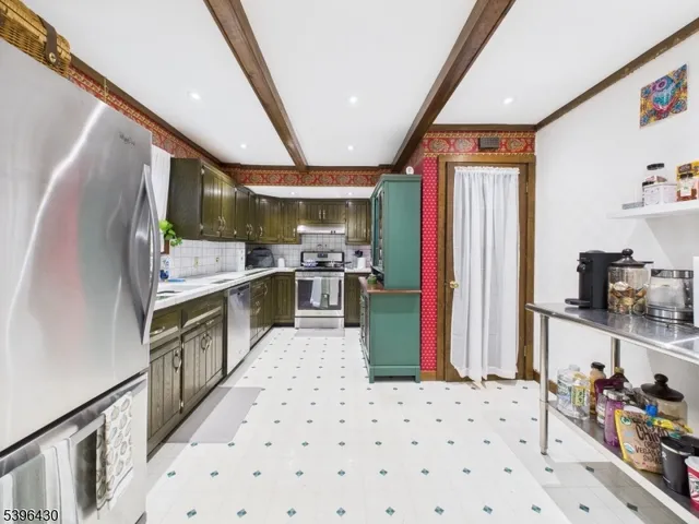 a kitchen with stainless steel appliances kitchen island granite countertop a refrigerator and a stove
