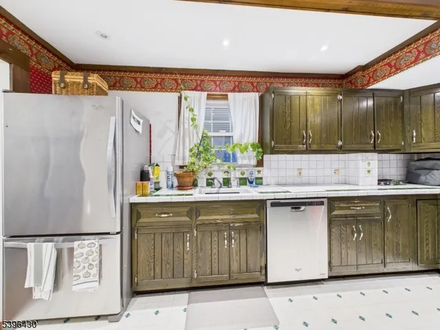 a kitchen with stainless steel appliances granite countertop a sink and a refrigerator