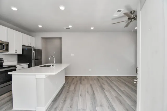 an empty room with closet and a chandelier fan