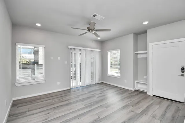 an empty room with fan and entrance