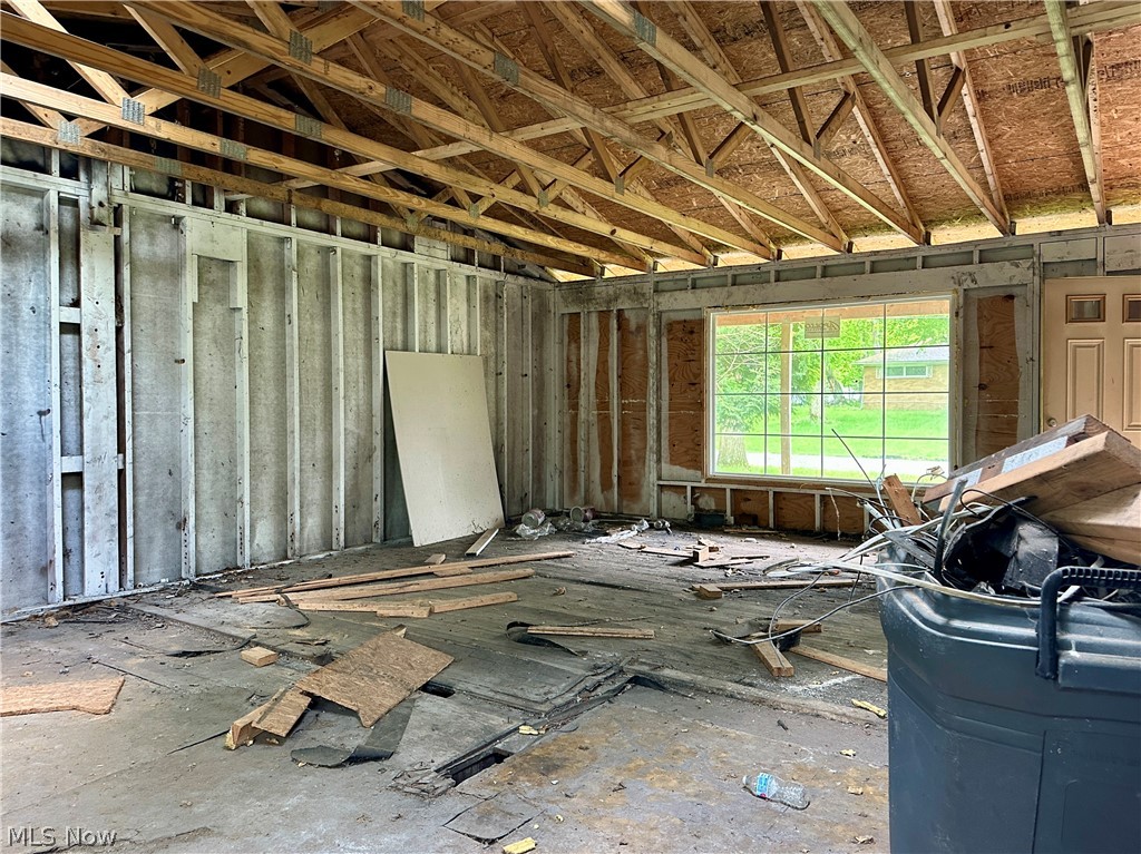 5319 Fairtree Road Bedford Heights, OH 44146 - Photo 10 of 27 Interior space featuring exposed ceiling trusses and wall studs, a large multi-pane window, and a solid-panel door frame