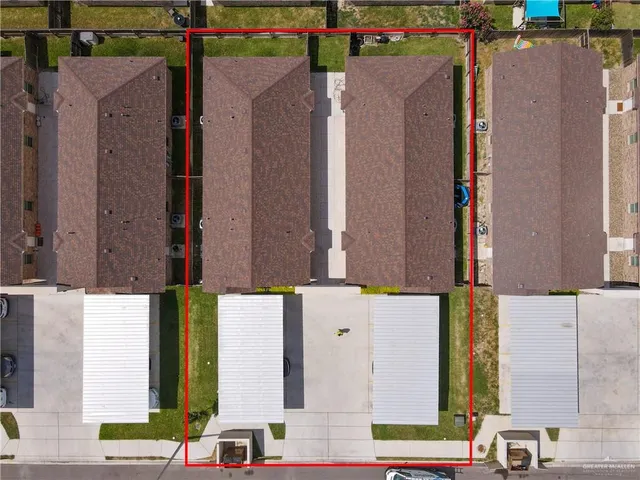 an aerial view of residential houses with outdoor space and parking