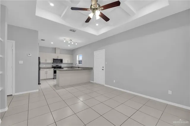 a view of an empty room and kitchen view